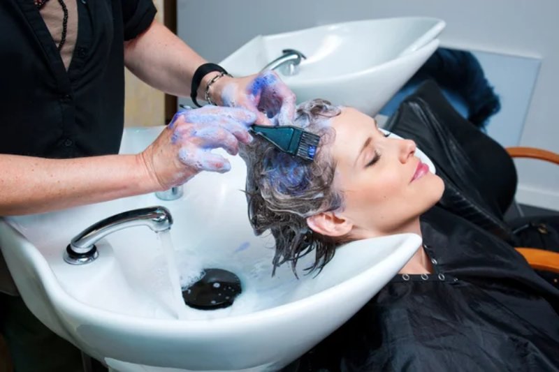 Femme colorant ses cheveux au salon 