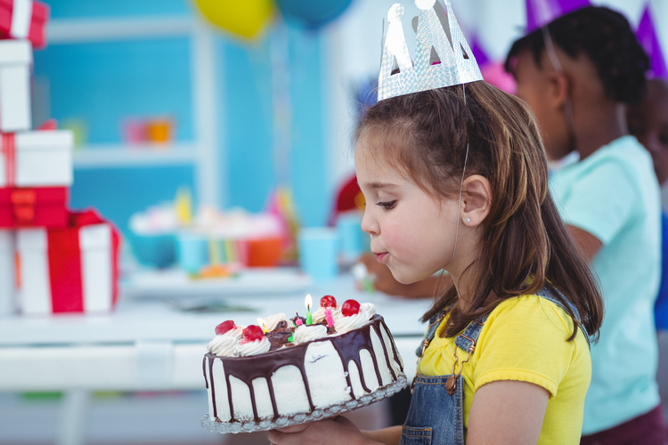 petite fille de 5 ans qui souffle ses bougies