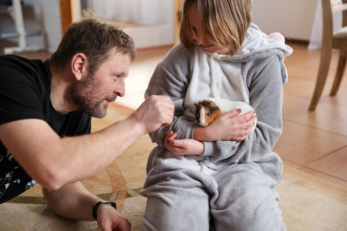 Un papa et son fils qui joue avec un hamster