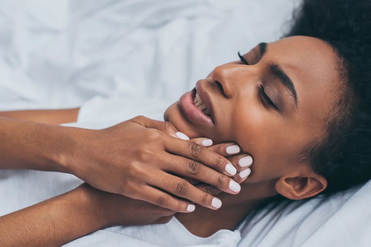 Une femme qui se masse la mâchoire 