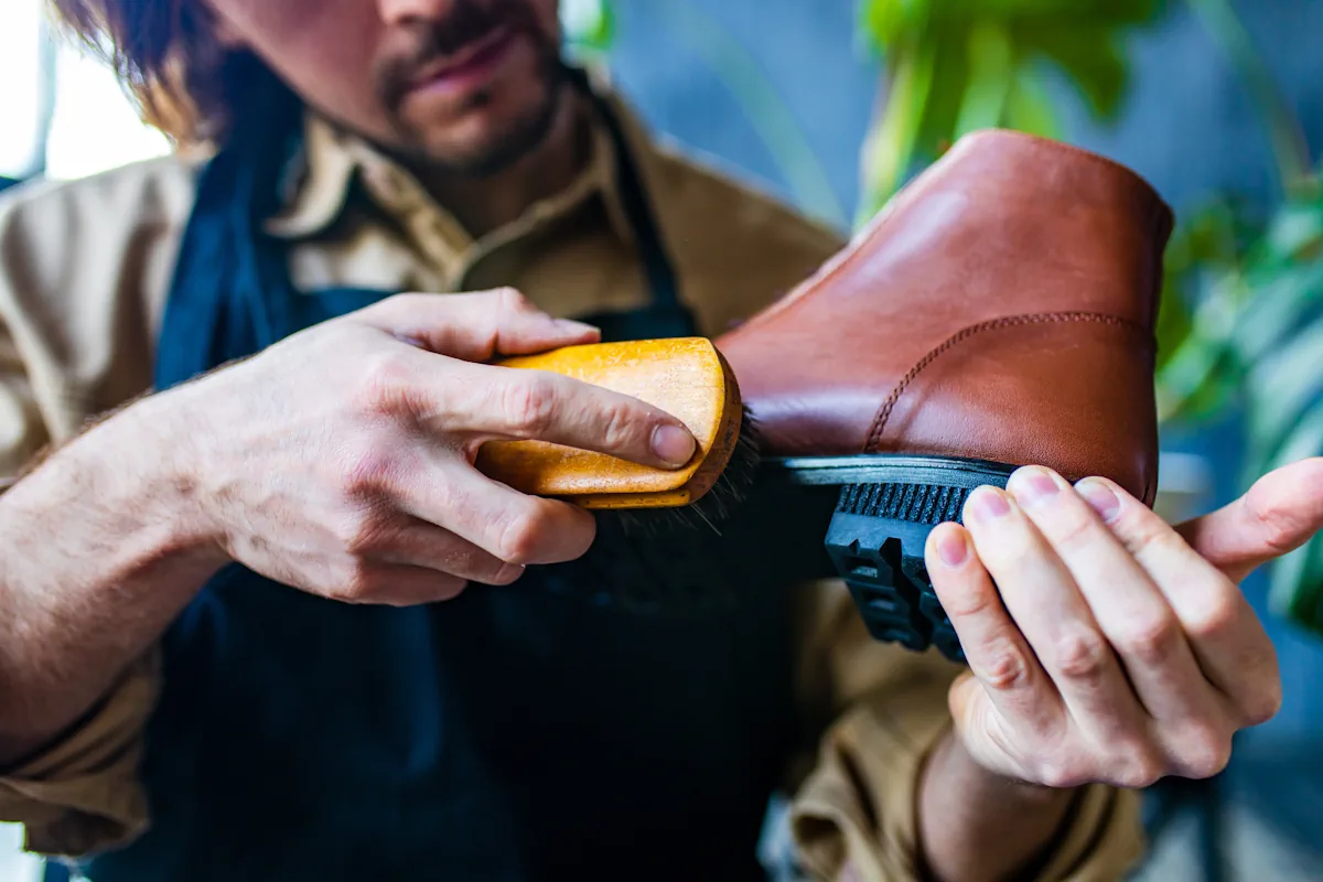 Un cordonnier qui traite une chaussure en cuir