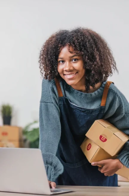 Une femme qui vend des vêtements en ligne devant son ordinateur