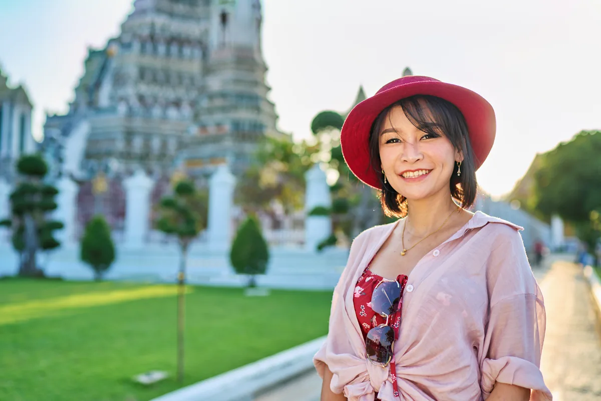 Une femme qui porte du rose pendant la visite de la Thaïlande
