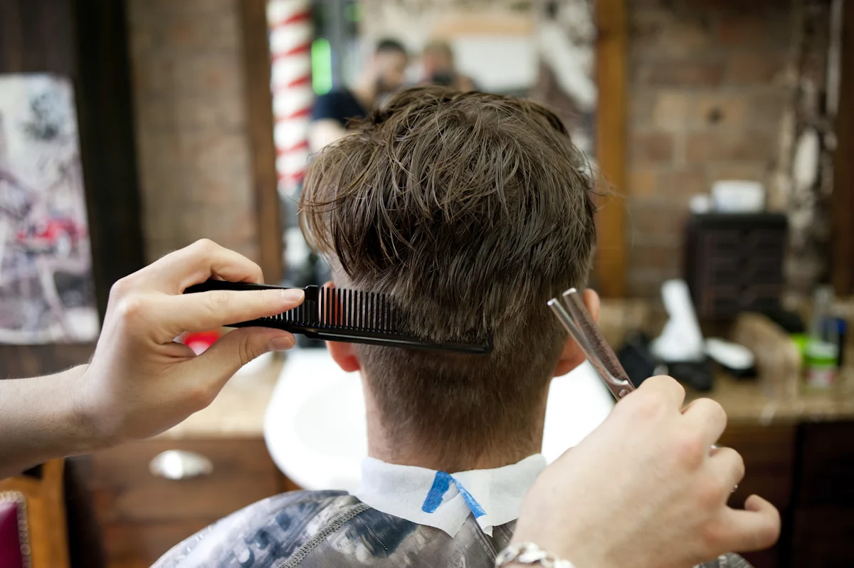 Un homme qui se fait faire une coupe chez le coiffeur
