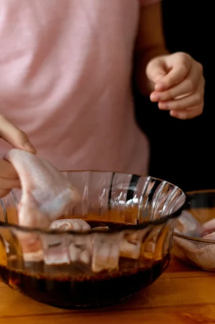 Une femme qui fait un marinade de poulet pour brochettes