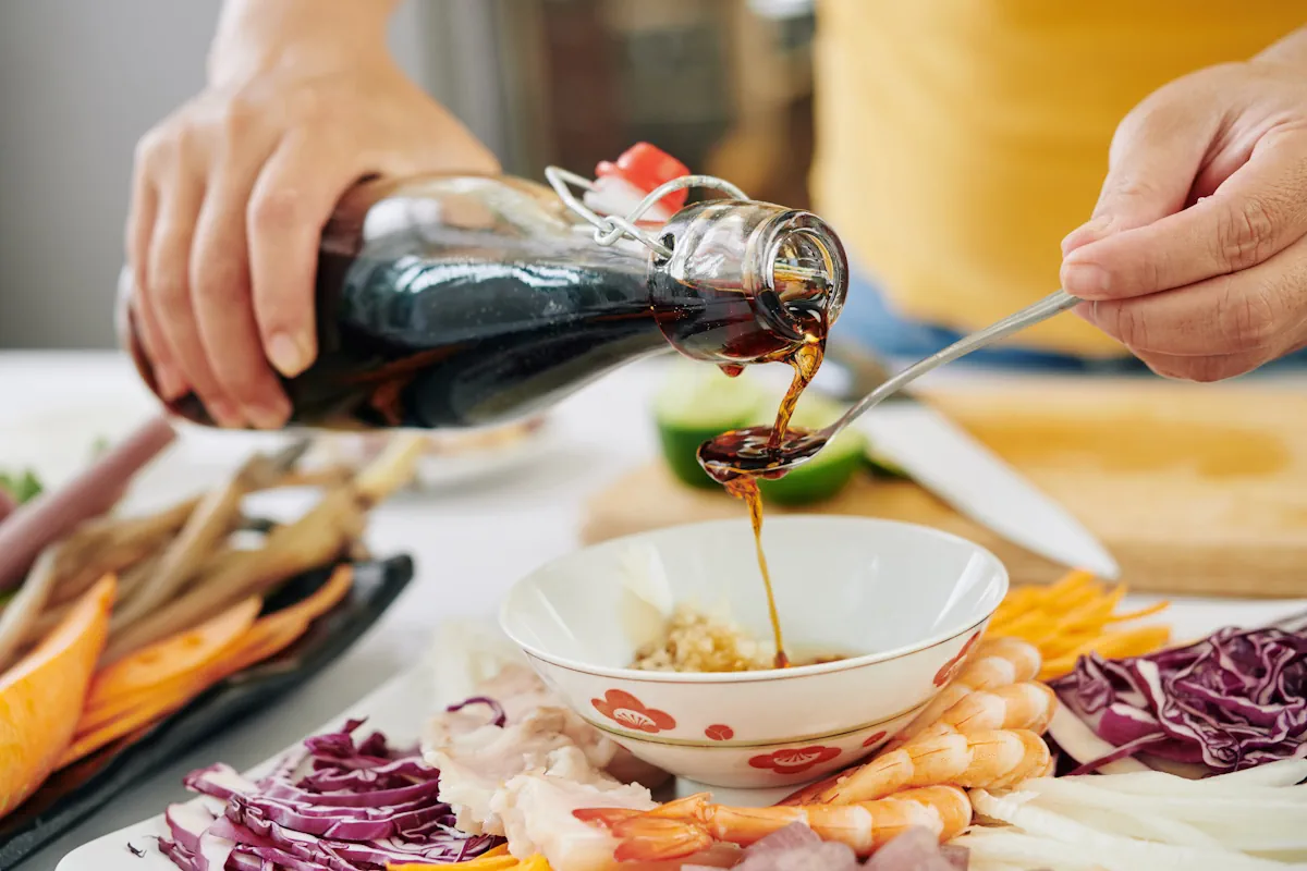 Une personne qui verse de la sauce soja dans une cuillière