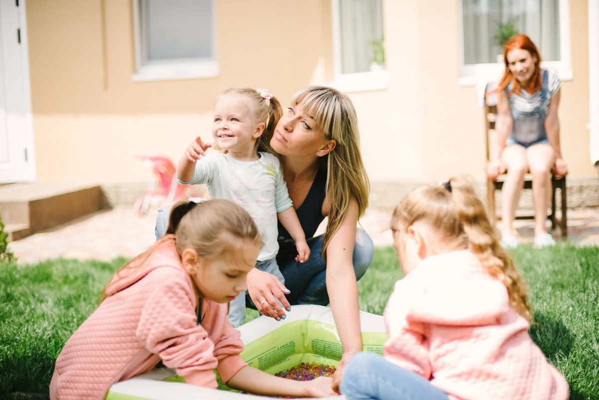 Une femme avec son enfant qui joue avec d'autres enfants